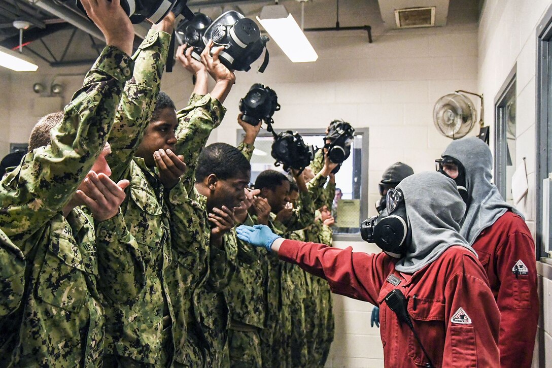Recruits recite their names and division numbers while experiencing the effects of tear gas.