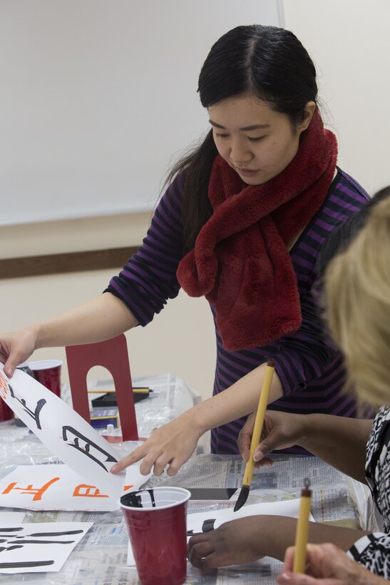 Students sit around a table practicing calligraphy