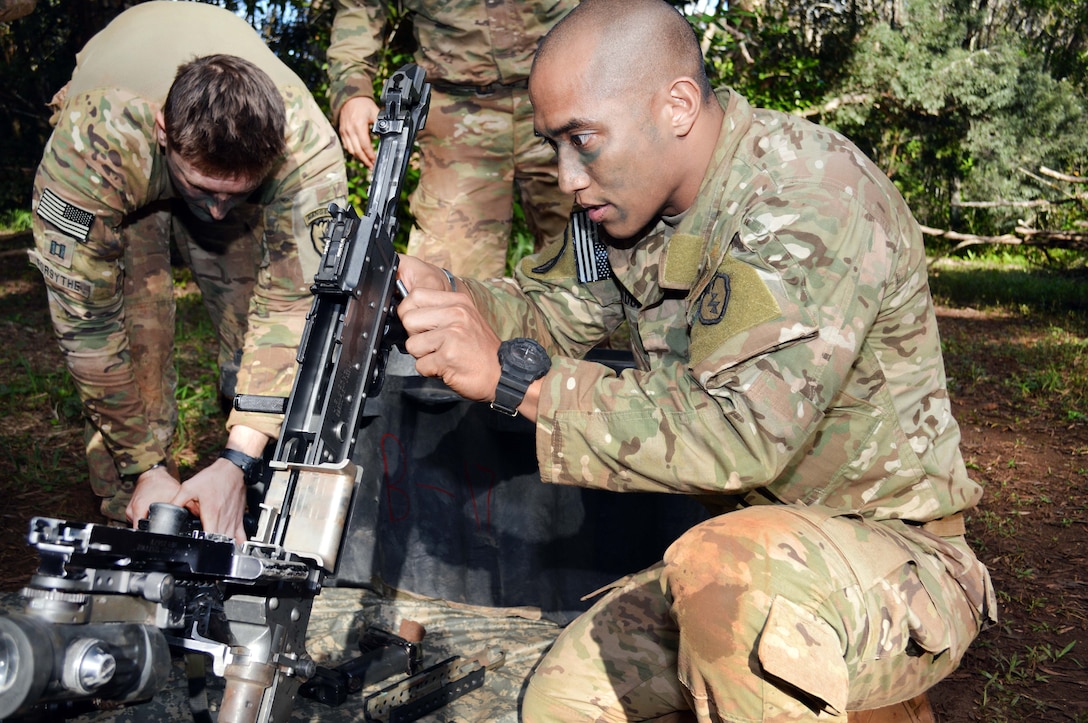Army 1st Sergeant Eugene Mirador assembles a M249 machine gun.