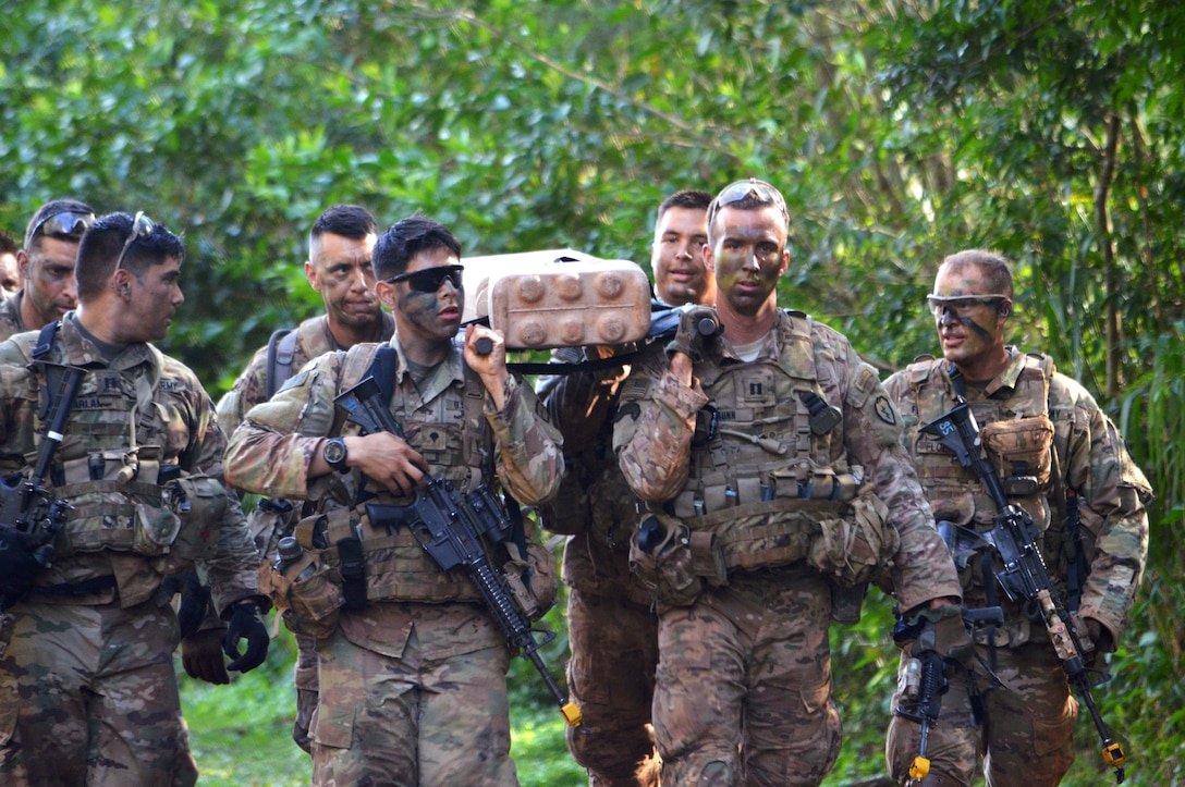 Soldiers carry a weighted litter on their march.