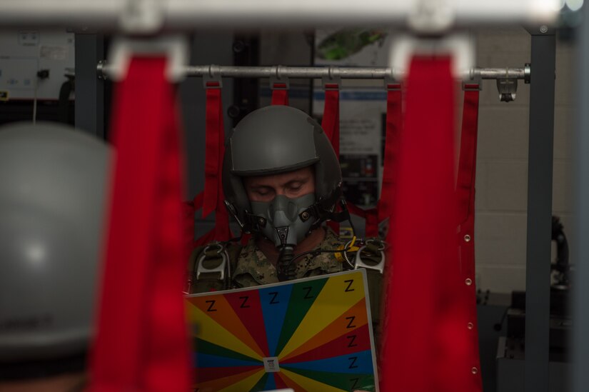 U.S. Navy Chief Petty Officer, Explosive Ordnance Disposal Mobile Unit 12 EOD chief, has his tested a color chart during hypoxia training at 1st Operations Group aerospace and operational physiology, Joint Base Langley-Eustis, Va., Dec. 5, 2017. Towards the end of hypoxia training the instructor turns down the lights and gives the person a card with alternating colors to test their vision while undergoing hypoxia. (U.S. Air Force photo by Airman 1st Class Tristan Biese)