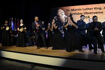 Fred McKinnon, master of ceremonies for the Dr. Martin Luther King, Jr. Birthday Celebration at Fort Eustis’ Wylie Theater, performs a dance with the Woodside High School Choir at Joint Base Langley-Eustis, Va., Jan. 11, 2018.