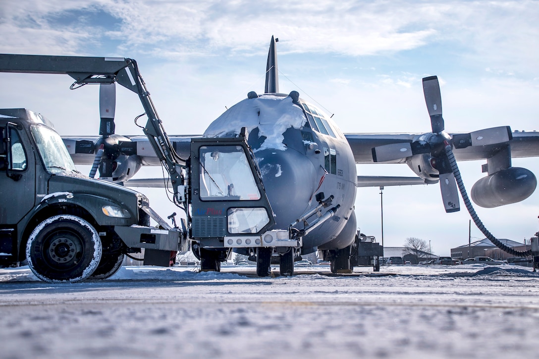 Guardsmen operate a deicing truck to remove ice and snow from the C-130H Hercules aircraft.