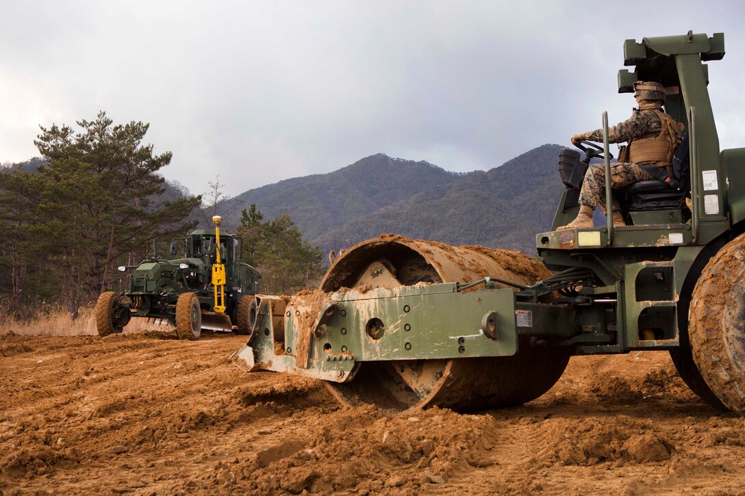 Marines operate heavy equipment to level out terrain.
