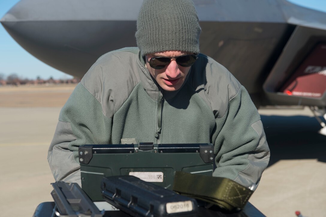 U.S. Air Force Staff Sgt. Justin Smith, 1st Aircraft Maintenance Squadron load crew chief, checks technical orders during the 4th Quarter Weapons Load Competition at Joint Base Langley-Eustis, Va., Jan. 2, 2018. Smith used the technical orders to ensure his team correctly completes all tasks, before his team loads an F-22 Raptor. (U.S. Air Force photo by Senior Airman Derek Seifert)