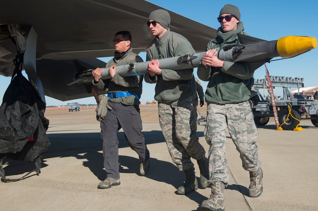 U.S. Air Force Airmen assigned to the 1st Aircraft Maintenance Squadron transport ammunition to a U.S. Air Force F-22 Raptor during the 4th Quarter Weapons Load Competition at Joint Base Langley-Eustis, Va., Jan. 2, 2018. Weapons load competitions are held every quarter to test the skills and abilities of load crews from different aircraft maintenance units. (U.S. Air Force photo by Senior Airman Derek Seifert)