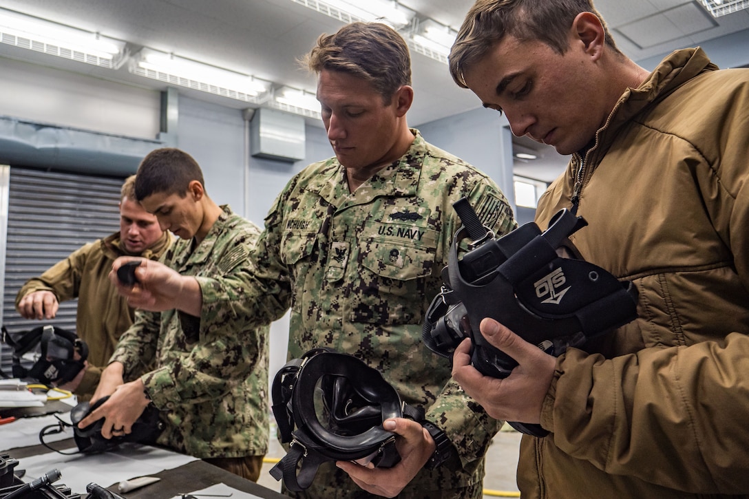 Seabees check their diving masks before going underwater.
