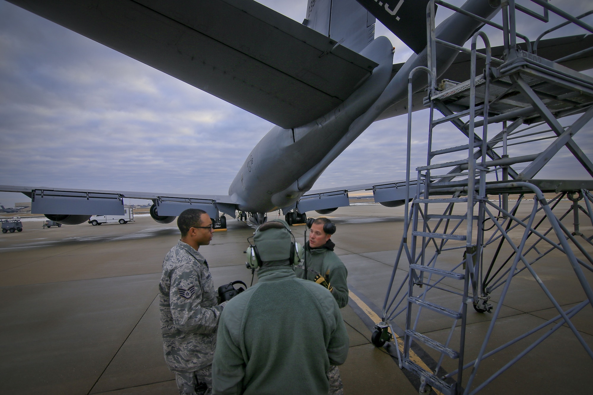 New Jersey Air National Guard Staff Sgt. Garion Reddick, left, an aircraft electronics specialist, talks with KC-135R crew chiefs Tech. Sgt. Raymond DeMarco, center, and Staff Sgt. Robert Cento, right, about a lighting issue on Joint Base McGuire-Dix-Lakehurst, N.J., Jan. 11, 2018. All three airmen are assigned to the 108th Wing. (U.S. Air National Guard photo by Master Sgt. Matt Hecht)