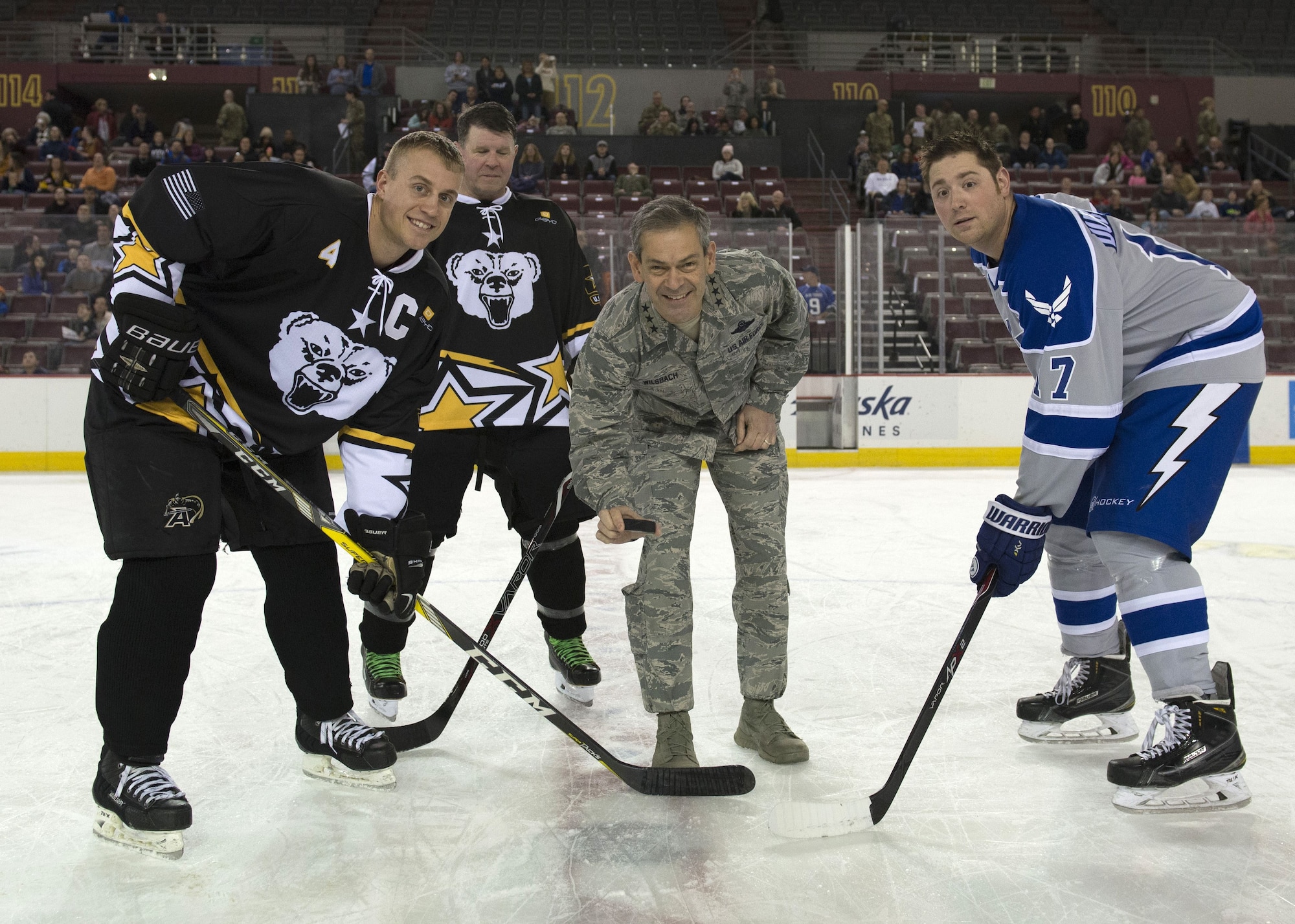 U.S. Air Force Lt. Gen. Kenneth S. Wilsbach, commander Alaskan Command, Alaska NORAD Region and 11th Air Force drops the ceremonial puck prior to the start of the 5th Annual Army vs. Air Force Hockey Game, Jan. 13, 2018, at the Sullivan Arena in Anchorage, Alaska. The game is played annually between teams made of service members assigned to Joint Base Elmendorf-Richardson, Alaska, promotes military esprit de corps and enhances the relationship between JBER and the Anchorage community.