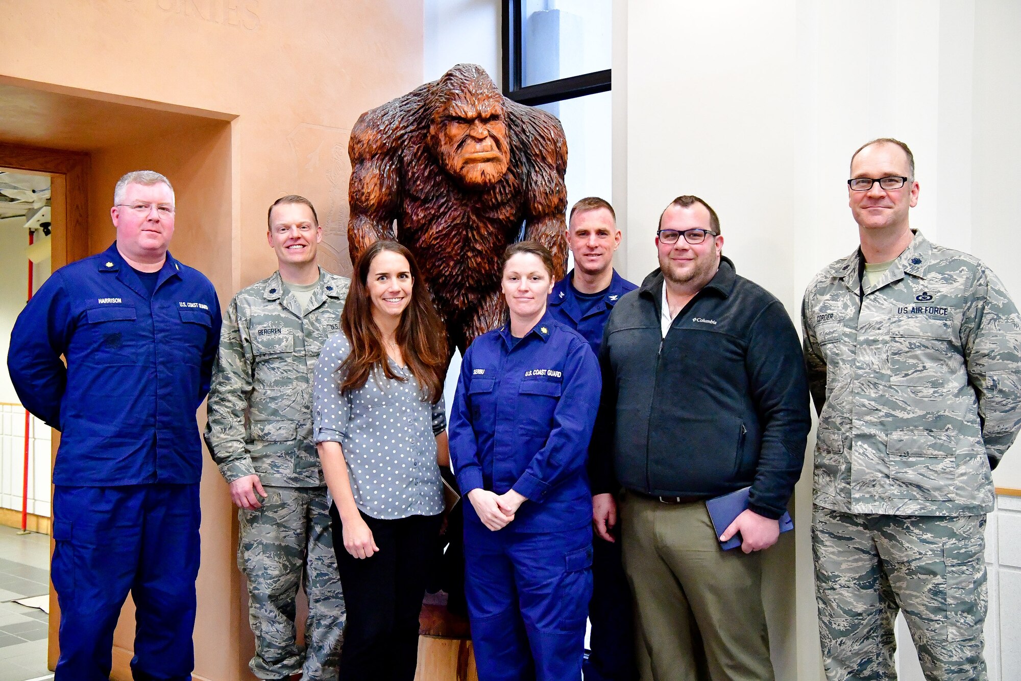Members of the U.S. Coast Guard 13th District (Seattle) and the Western Air Defense Sector take a group photo in from of the WADS mascot, Bigfoot, after a morning of search and rescue cross-talk.  Pictured from left to right are: U.S. Coast Guard Lt. Cmdr. Courtney Harrison, U.S. Air Force Lt. Col. Brian Bergren, U.S. Coast Guard SAR expert Morgan Mak, U.S. Coast Guard Lt. Cmdr. Brook Serbu, U.S. Coast Guard Capt. Sean Cross, , U.S. Coast Guard SAR expert Scott Giard, and U.S. Air Force Lt. Col. Eric Corder.
