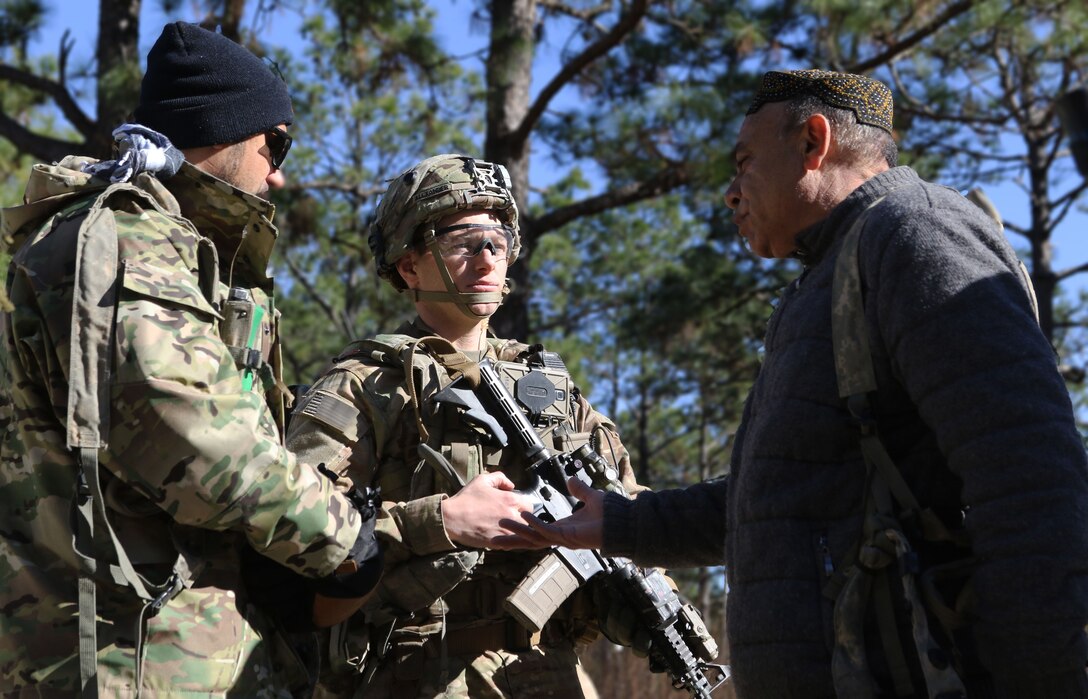 Afghan National Defense Security Forces role players talk to Capt. Justin Alexander, a combat team advisor team leader assigned to the 1st Security Force Assistance Brigade during a simulated event at the Joint Readiness Training Center at Fort Polk, La., Jan. 13, 2018. The JRTC rotation was conducted in order to prepare the newly formed 1st SFAB for an upcoming deployment to Afghanistan in the spring of 2018. SFAB’s provide combat advising capability while enabling brigade combat teams to prepare for decisive action, improving readiness of the Army and its partners. (U.S. Army photo by Pfc. Zoe Garbarino/Released)