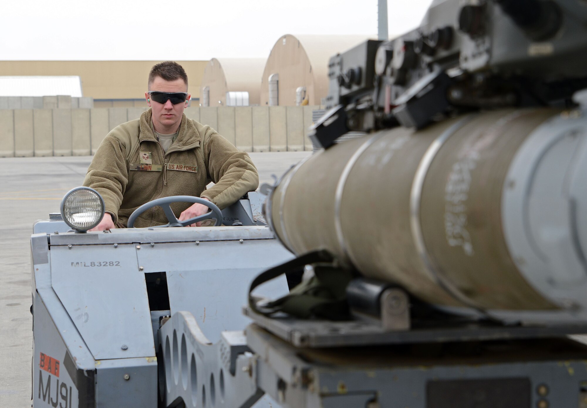 Senior Airman Kaleb Linn, 455th Expeditionary Aircraft Maintenance Squadron weapons load crew member, loads a munition onto an F-16 Fighting Falcon using a jammer Jan. 4, 2018 at Bagram Airfield, Afghanistan.