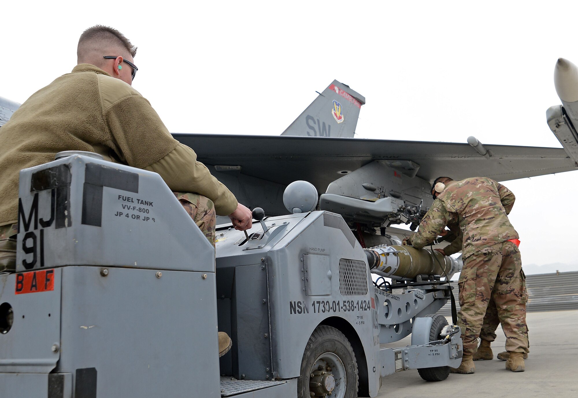 Senior Airman Kaleb Linn, 455th Expeditionary Aircraft Maintenance Squadron weapons load crew member, loads a munition onto an F-16 Fighting Falcon using a jammer Jan. 4, 2018 at Bagram Airfield, Afghanistan.