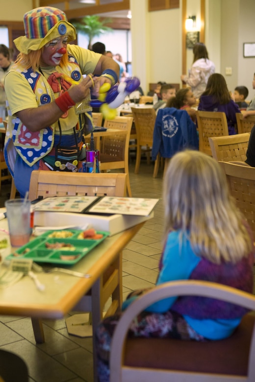 A clown makes a balloon animal for a child during the Winter Wonderland Family Fun Night at the Ocean Breeze Jan. 17 aboard Camp Foster, Okinawa, Japan. Children colored snowflakes, watched “Frozen” and made s’mores at the s’mores bar. Coming out to the Ocean Breeze allows families a chance to know their community and neighbors a little better. (U.S. Marine Corps photo by Pfc. Nicole Rogge)