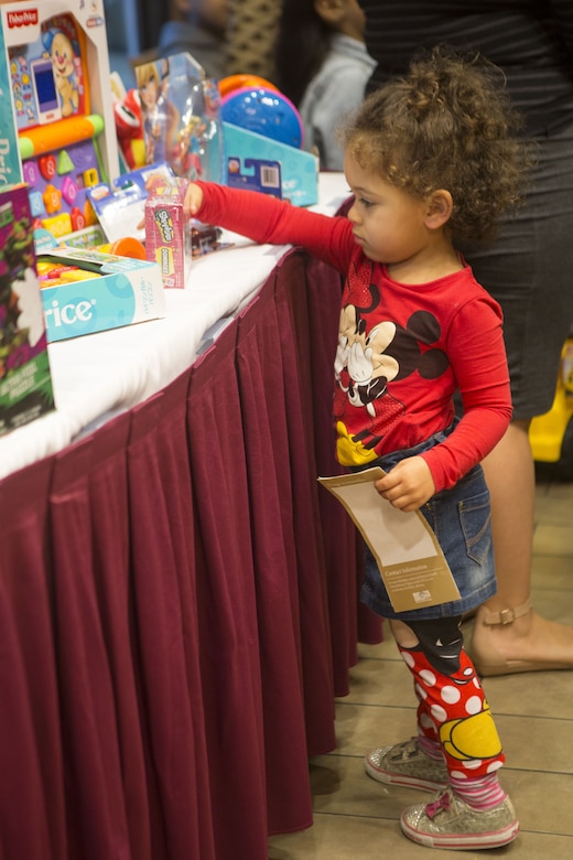 A child picks out a toy during the Winter Wonderland Family Fun Night at the Ocean Breeze Jan. 17 aboard Camp Foster, Okinawa, Japan. The Ocean Breeze gave each child a toy upon entering the event. Children colored snowflakes, watched “Frozen” and made s’mores at the s’mores bar. Coming out to the Ocean Breeze allows families a chance to know their community and neighbors a little better. (U.S. Marine Corps photo by Pfc. Nicole Rogge)