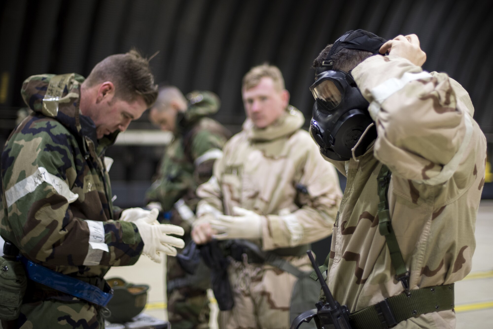 Members of the 48th Fighter Wing remove chemical and biological protective gear after a simulated threat during an Ability to Survive and Operate exercise at Royal Air Force Lakenheath, England, Jan. 16. The exercise helps ensure Airmen are trained and ready to operate across the spectrum of operating domains. (U.S. Air Force photo/Senior Airman Malcolm Mayfield)