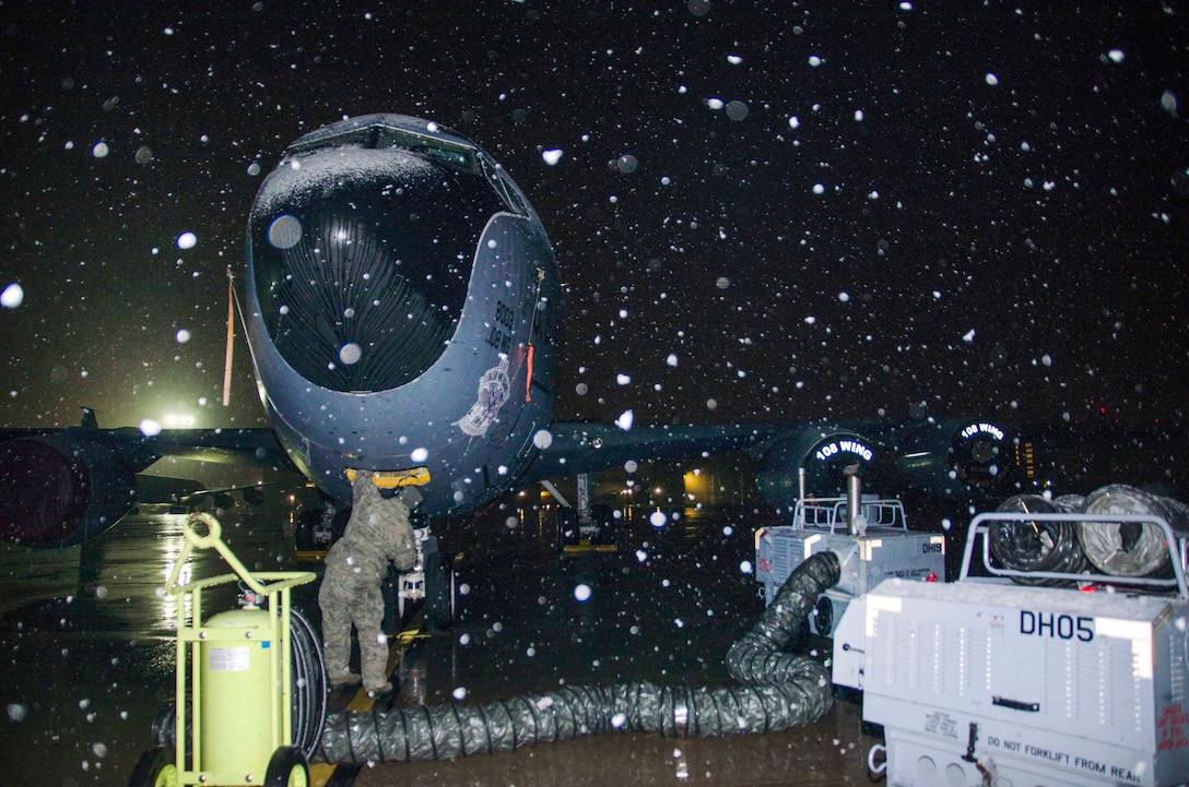 Master Sgt. Frank Diliberto performs preflight inspection on a KC-135 Stratotanker before a flight during a snow shower.