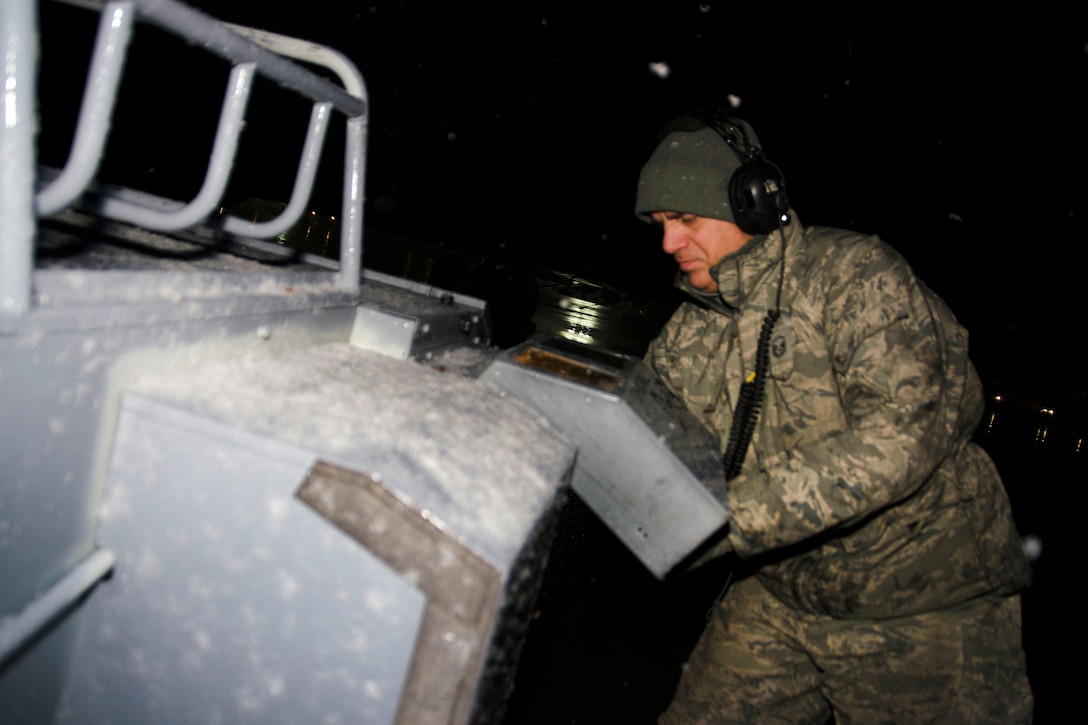 Master Sgt. Frank Diliberto prepares a KC-135 Stratotanker before a flight during a snow shower.