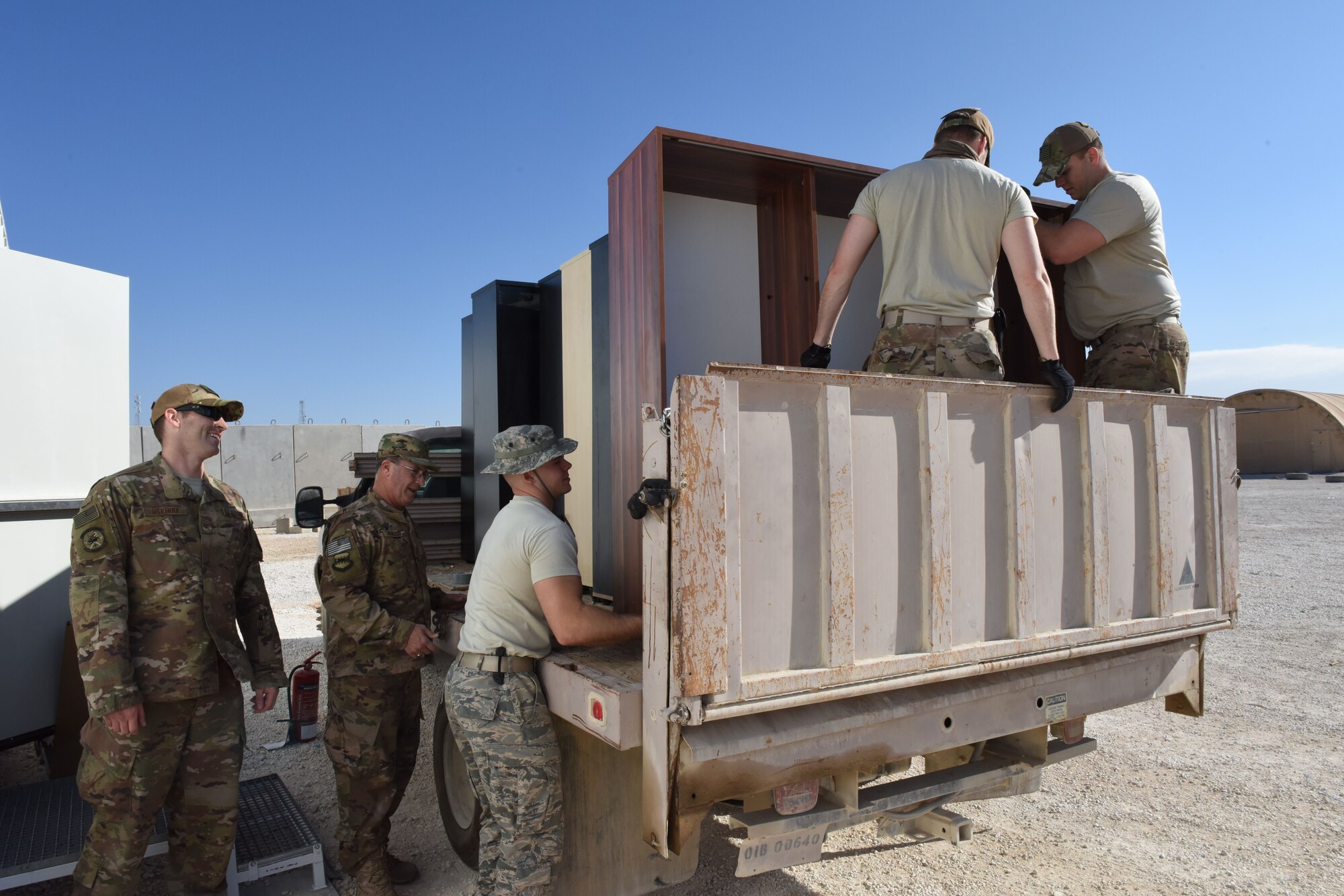 U.S. Air Force Maj. Raymond Moncrief, 332 Air Expeditionary Wing Chaplain, observes a group of 332nd Civil Engineer Force Protection Airmen while they move furniture into the new Oasis Recreation Center Jan. 18, 2018. The previous recreation center was located in a tent. (U.S. Air Force photo by Staff Sgt. Antonio Gonzalez/Released)