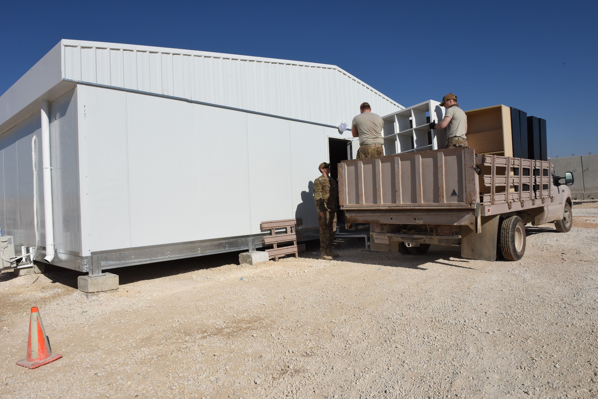 Airmen assigned to 332nd Civil Engineer Force Protection section move furniture into the new Oasis Recreation Center Jan. 18, 2018. With the help of the 332nd Contracting Squadron, the recreation center was able to upgrade to a modular building in place of a tent. (U.S. Air Force photo by Staff Sgt. Antonio Gonzalez/Released)