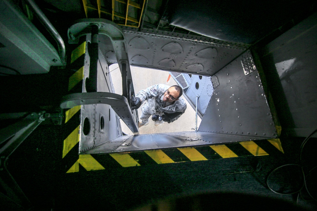 Staff Sgt. Garion Reddick descends down a ladder on a KC-135R Stratoanker after performing electrical work on the aircraft.