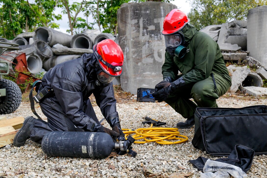 Army Reserve soldiers prepares a compressed air tank.