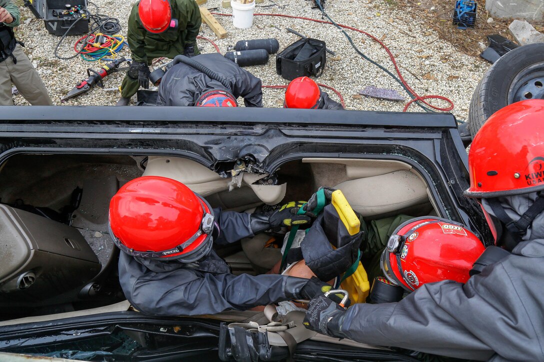 Army Reserve soldiers extract a dummy casualty from an overturned vehicle.