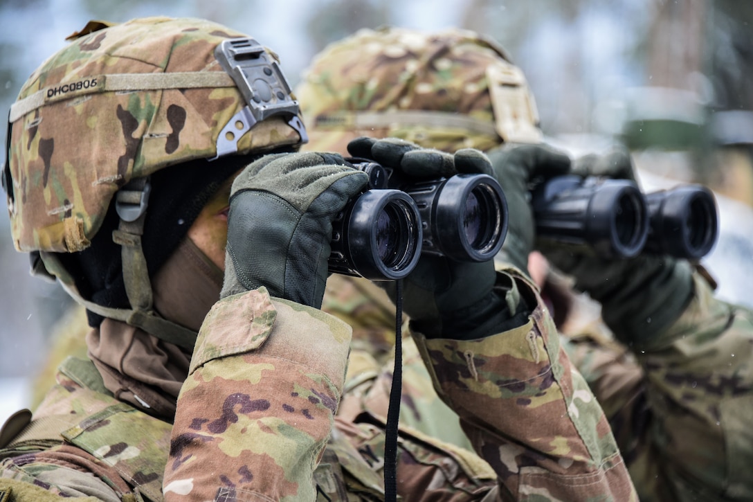 Two soldiers looking through binoculars.