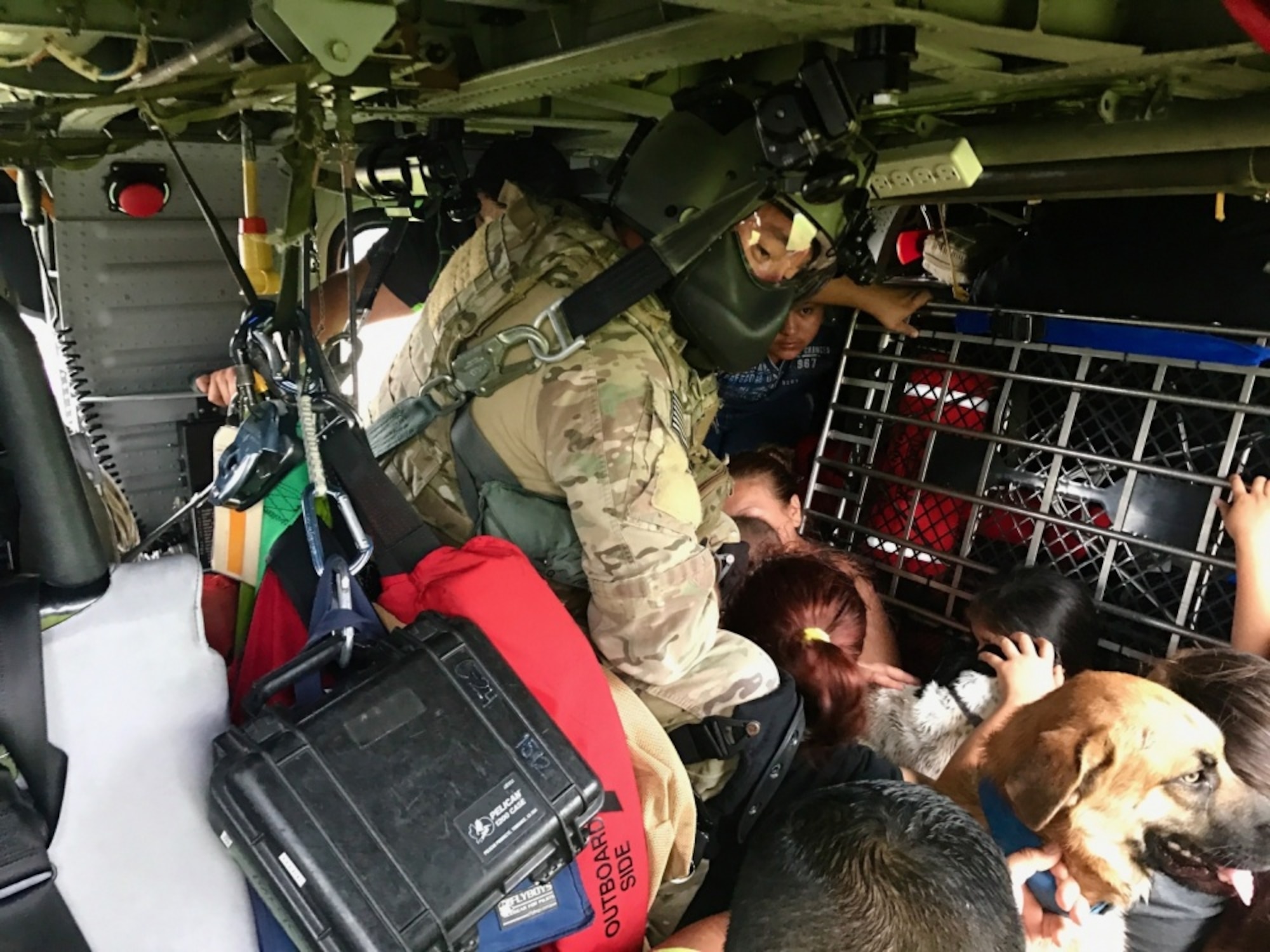 Senior Airman Davy Brinkmann, 920th Rescue Wing, Patrick Air Force Base, Florida, special missions aviations specialist, gets sight on a fellow pararescuemen below as they prepare to hoist two stranded victims of Hurricane Harvey Aug. 31, 2017 from Beaumont, Texas.