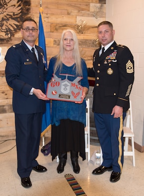 Lt. Col. Claudio Covacci, 60th MXS commander(left), Michelle Marinucci, daughter of late Chief Master Sgt. George R. Tucker(center), and James Marinucci, grandson of late Chief Master Sgt. George R. Tucker(right), stand with a plackard the 60th Maintenance Squadron presented to Tucker's family in tribute to the work he accomplished for the squadron while he was alive January 12 at Travis Air Force Base, Calif. Tucker worked at Travis from 1964 until his retirement in 1985.