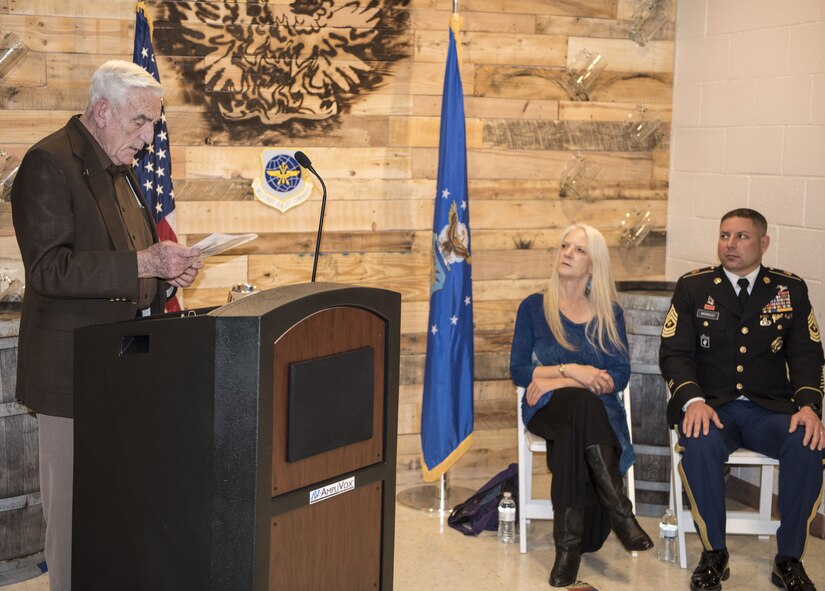 Retired Chief Master Sgt. James "Andy" Anderson(left) makes a speech about late Chief Master Sgt. George R. Tucker while his family, Michelle Marinucci, daughter of Tucker(center), and James Marinucci, grandson of Tucker(right) look on. Both Anderson and Tucker were assigned to Travis in 1964 and spent many years working together.(U.S. Air Force photo by Airman 1st Class Christian Conrad/Released)