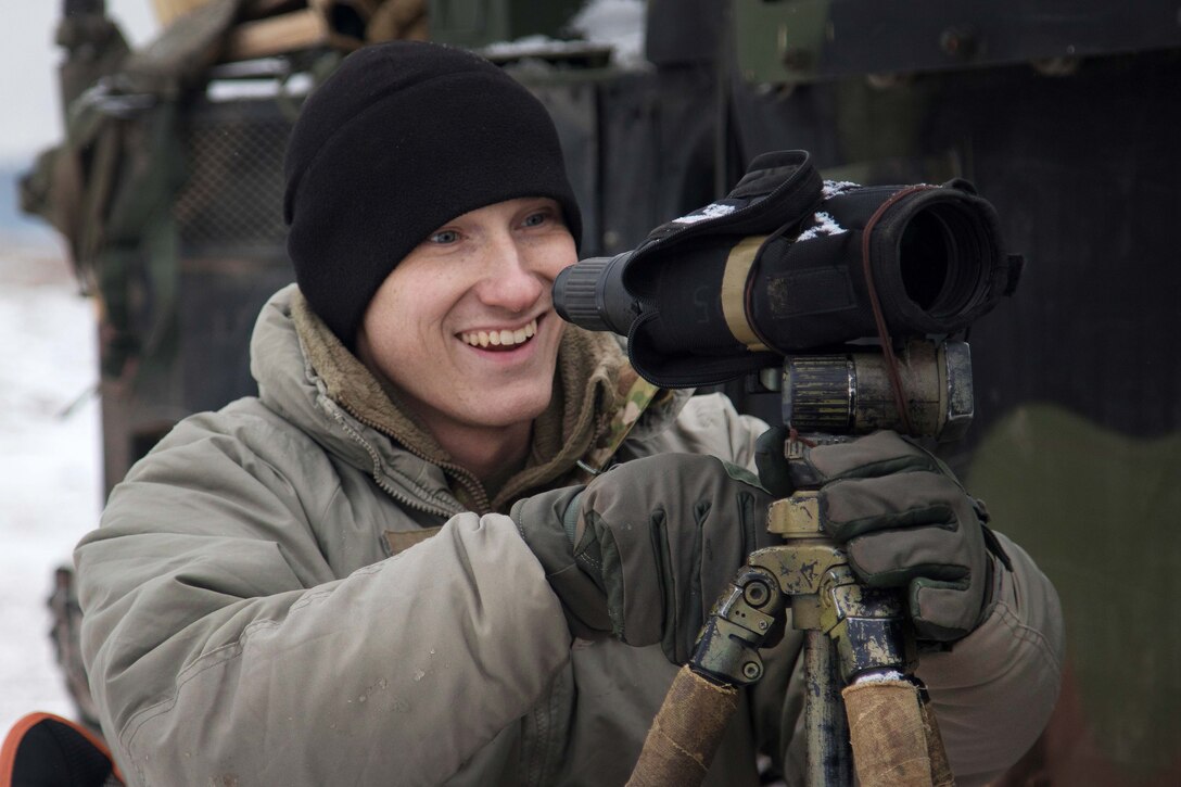 A soldier sets up a spotter scope.