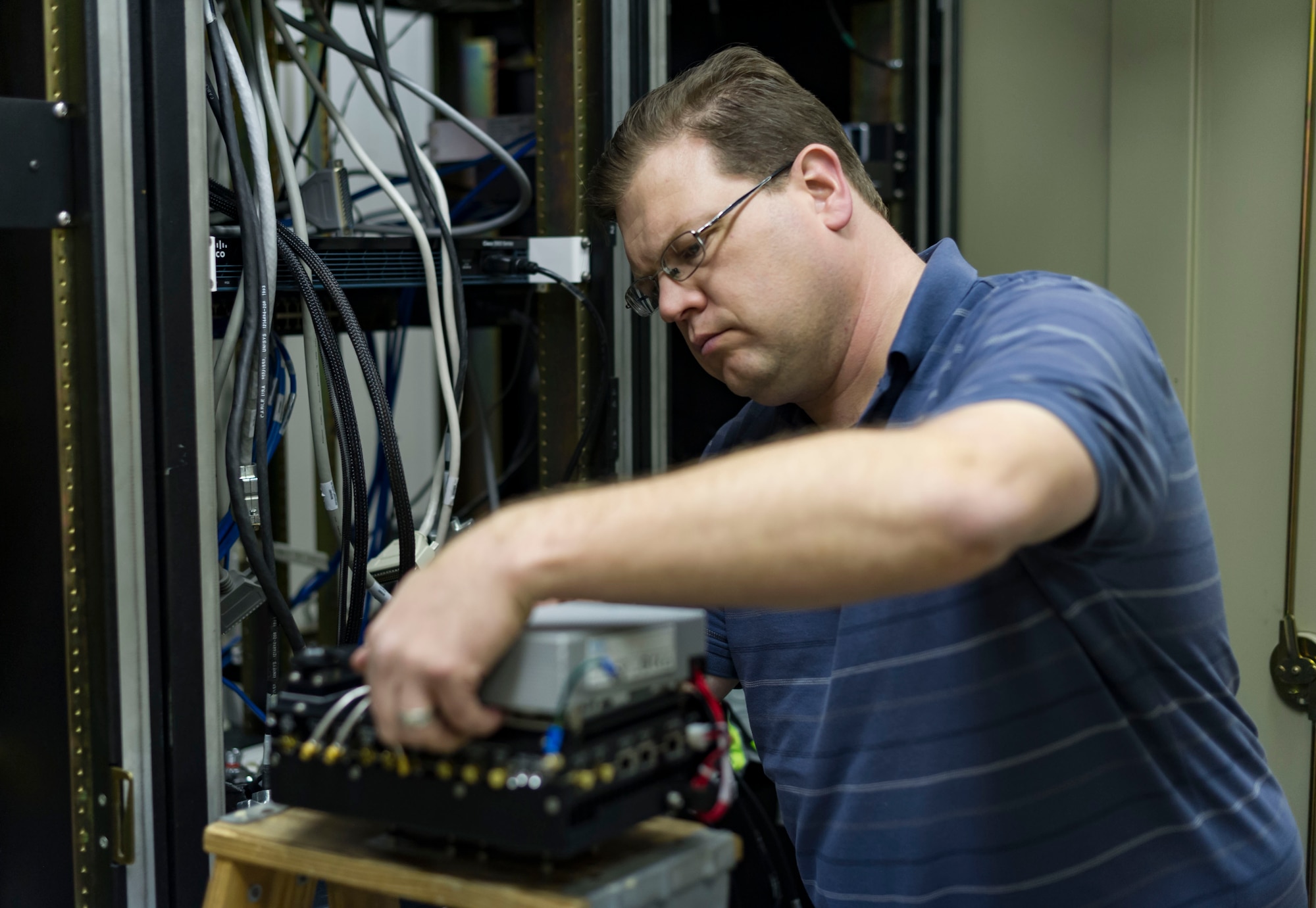 Brock Kerzmann, 47th Operations Support Squadron radar airfield weather systems electronic technician, refurbishes an electronic device used by the NexRAD WSR-88D weather radar outside Laughlin Air Force Base, Texas, Jan. 11, 2017. The radar services a wide area as part of a network of radars used to forecast weather conditions at a further distance than any other system available. (U.S. Air Force photo/Airman 1st Class Daniel Hambor)