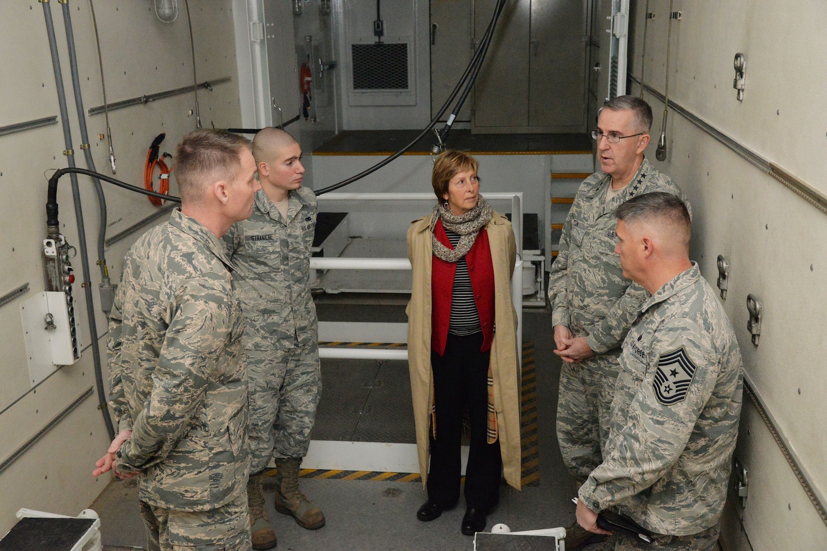 U.S. Air Force Gen. John Hyten, commander of U.S. Strategic Command (USSTRATCOM); his wife Laura; and Chief Master Sgt. Patrick McMahon, senior enlisted leader of USSTRATCOM, speak with Col. David Miller, 341st Maintenance Group commander, and Senior Airman Richard Straniere, 341st Maintenance Group maintainer, while touring a payload transporter in the maintenance bay at Malmstrom Air Force Base, Mont., Jan. 16, 2018.