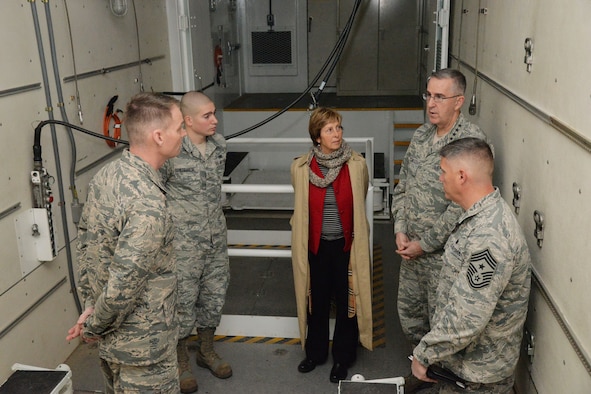 U.S. Air Force Gen. John Hyten, commander of U.S. Strategic Command (USSTRATCOM); his wife Laura; and Chief Master Sgt. Patrick McMahon, senior enlisted leader of USSTRATCOM, speak with Col. David Miller, 341st Maintenance Group commander, and Senior Airman Richard Straniere, 341st Maintenance Group maintainer, while touring a payload transporter in the maintenance bay at Malmstrom Air Force Base, Mont., Jan. 16, 2018.