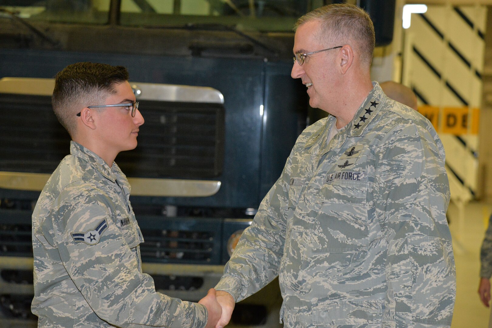 U.S. Air Force Gen. John Hyten, commander of U.S. Strategic Command (USSTRATCOM), speaks with Airman 1st Class Steven Navarro, 741st Maintenance Squadron vehicle and equipment section technician, in the maintenance bay at Malmstrom Air Force Base, Mont., Jan. 16, 2018.