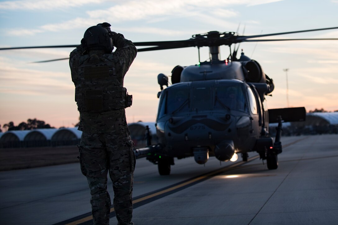 A special missions aviator assigned to the 41st Rescue Squadron directs an HH-60G Pave Hawk to a refueling point for hot-pit refueling operations, Jan. 16, 2018 at Moody Air Force Base, Ga. Airmen who work in the petroleum, oils and lubricants (POL) flight frequently use hot pit refueling, which is a more efficient tactic that allows aircrews a quick transition from the flight line back to their current objective. (U.S. Air Force photo by Senior Airman Daniel Snider)