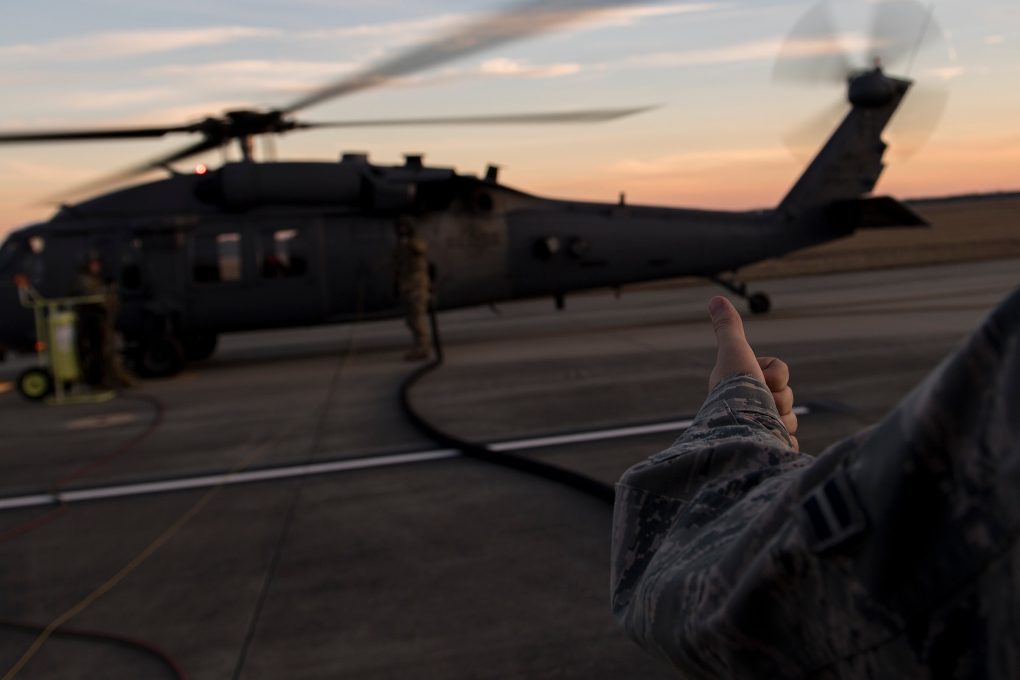 Airman 1st Class Evan Valance, 23d Logistics Readiness Squadron fuels distribution operator, communicates with a special missions aviator assigned to the 41st Rescue Squadron during HH-60G Pave Hawk hot-pit refueling operations, Jan. 16, 2018 at Moody Air Force Base, Ga. Airmen who work in the petroleum, oils and lubricants (POL) flight frequently use hot pit refueling, which is a more efficient tactic that allows aircrews a quick transition from the flight line back to their current objective. (U.S. Air Force photo by Senior Airman Daniel Snider)