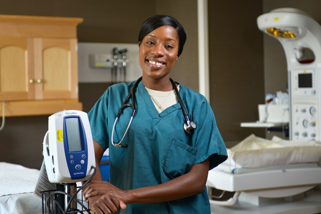 A woman poses for a photo next to medical equipment.