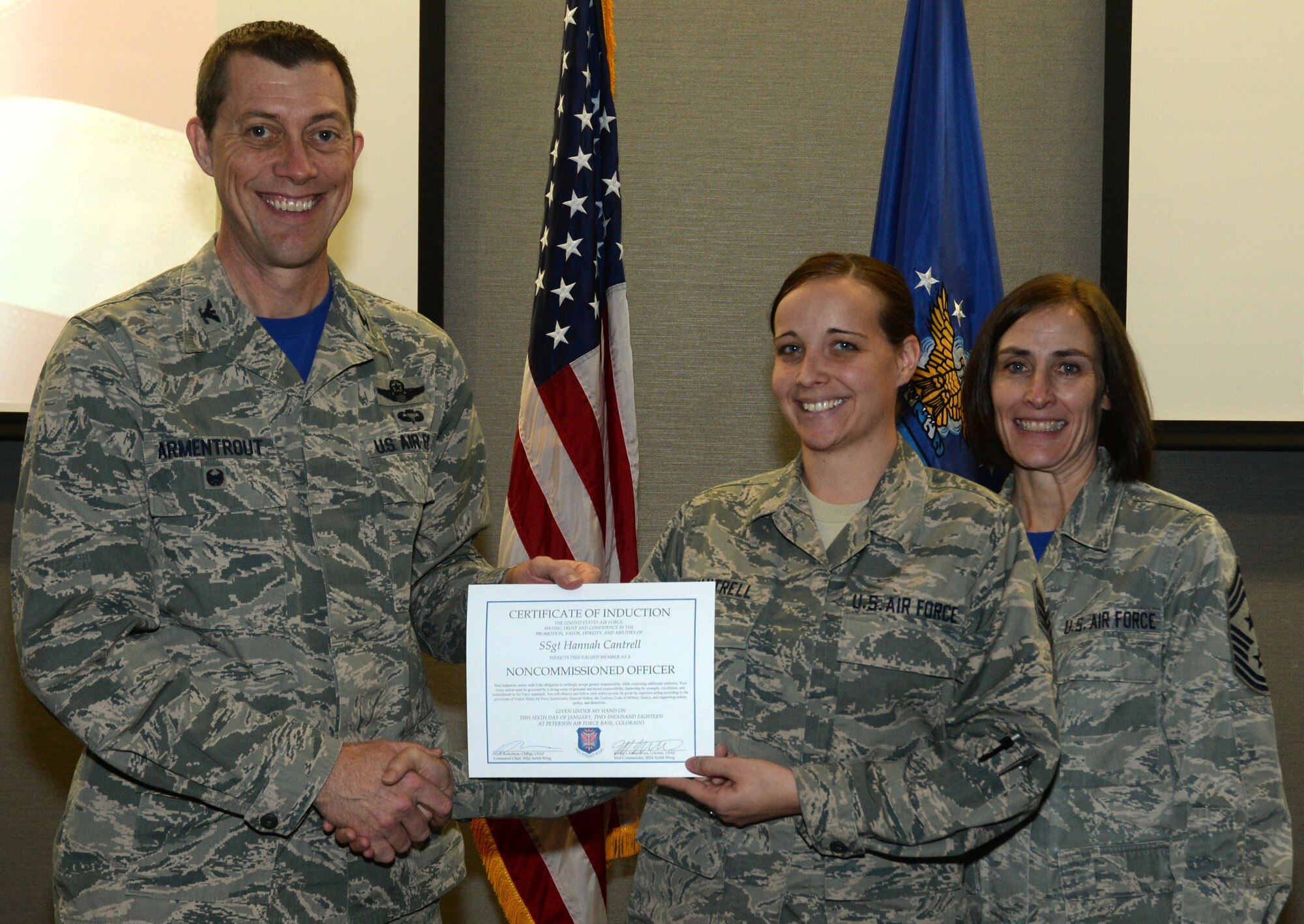 Col. Jeffrey Armentrout, the 302nd Airlift Wing vice wing commander, left, and Chief Master Sgt. Vicki Robertson, the 302nd AW command chief, present a Certificate of Induction to Staff Sgt. Hannah Cantrell, a 302nd Force Support Squadron services technician, Jan. 5, 2018, at Peterson Air Force Base, Colorado. Armentrout presented the certificates during the Reserve wing’s inaugural NCO Induction Ceremony dedicated to Reserve Citizen Airmen who recently promoted to the NCO tier of the enlisted ranks. (U.S. Air Force photo/Staff Sgt. Justin Norton)