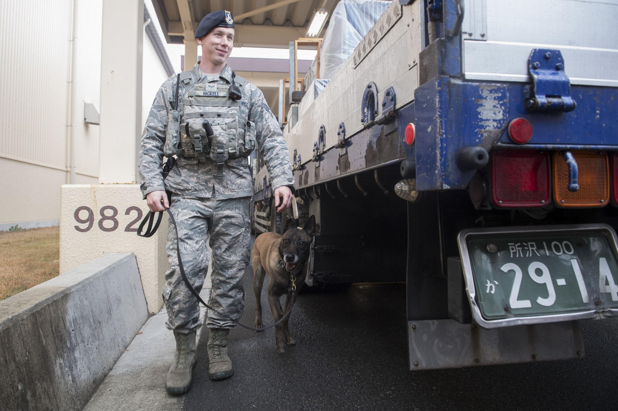 Senior Airman Cody Nickell, 374th Security Forces Squadron military working dog handler, and Topa, 374 SFS MWD, search a vehicle for explosives and other prohibited substances, Jan. 18, 2018, at Yokota Air Base, Japan.