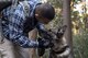Senior Airman Mario Hernandez, 374th Security Forces Squadron military working dog handler, gives Demo, 374 SFS MWD, praise for a job well done during regular MWD human detection training, Jan. 11, 2018, at Tama Hills Recreation Area, Japan.