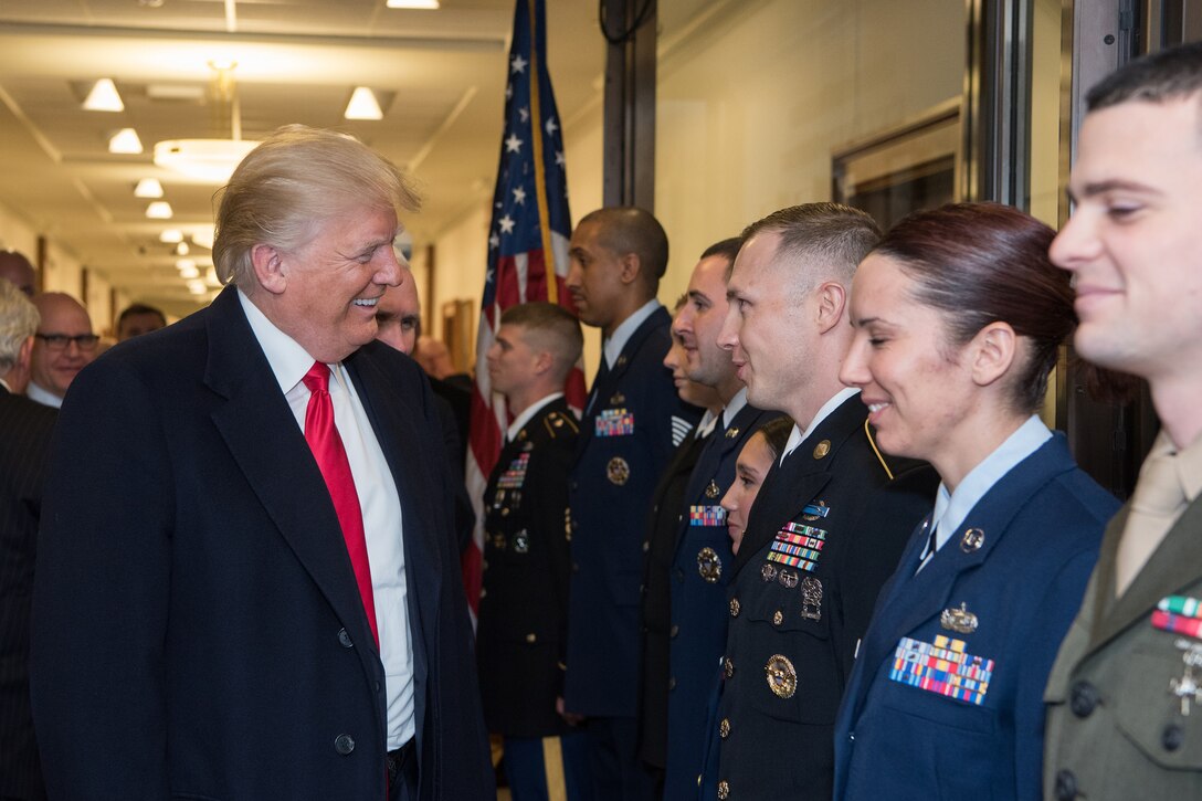 President Donald J. Trump smiles as he meets eight service members.