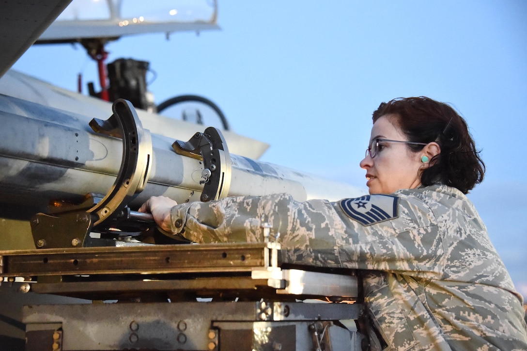 An airman prepares to download a training missile off of an F-15C Eagle fighter aircraft.