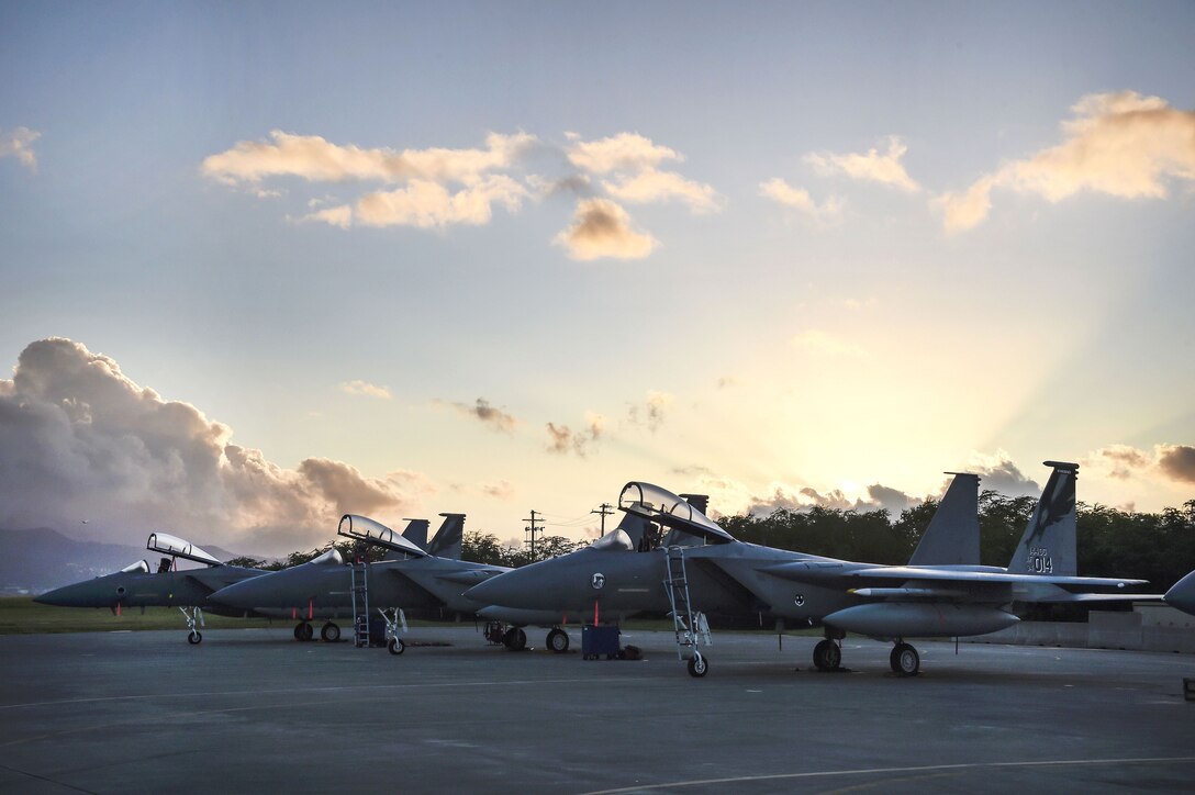 Three Air Force F-15C Eagle fighter aircraft stand ready for a morning mission.
