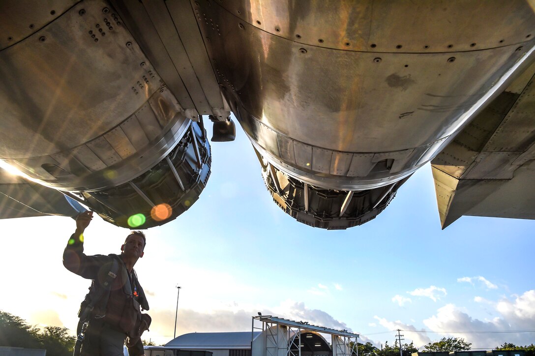 An airman performs a pre-flight inspection of an F-15C Eagle fighter aircraft.