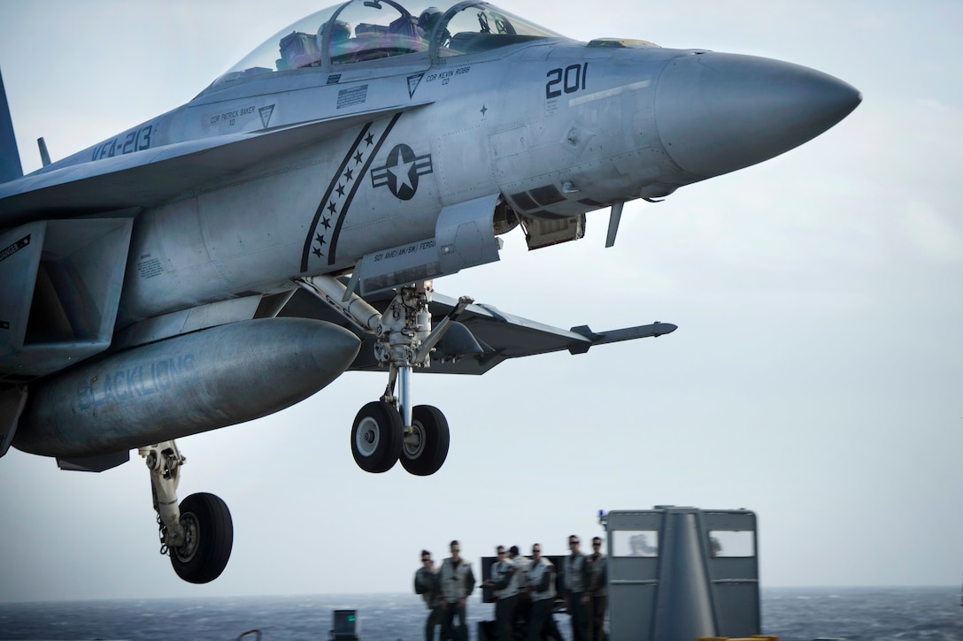 An F/A-18F Super Hornet aircraft prepares to land on the flight deck of the USS Gerald R. Ford.