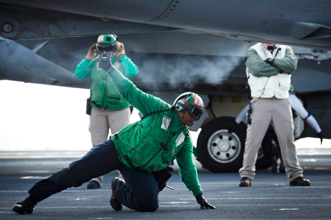 A sailor signals to the shooter that the aircraft is prepared to launch.