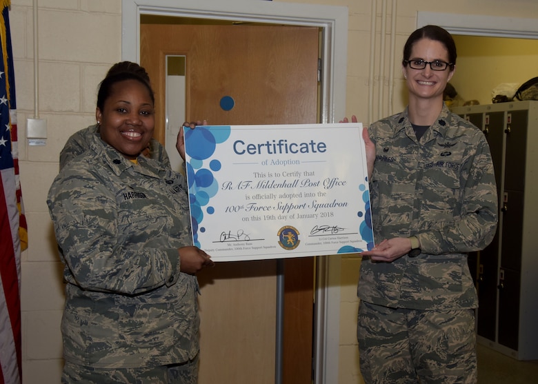 U.S. Air Force Lt. Col. Carina Harrison, 100th Force Support Squadron commander, and Lt. Col. Stacie Voorhees, 100th Communications Squadron commander, hold a certificate designating the post office as a flight of the 100th FSS at RAF Mildenhall, England Jan. 19, 2018. The reclassification brings mission support agencies into the same squadron. (U.S. Air Force photo by Senior Airman Justine Rho)