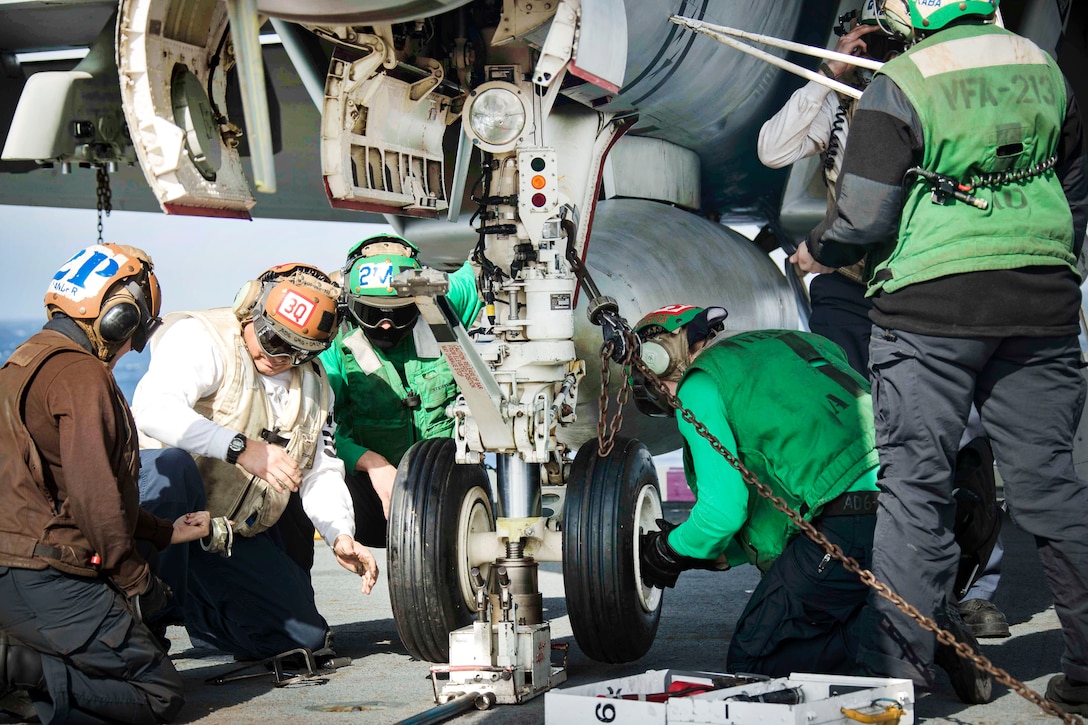 Sailors change the tire of an F/A18F Super Hornet aircraft on the flight deck of the USS Gerald R. Ford.